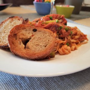 Spaghetti met tonijn in tomatensaus geserveerd met in de pan gebakken olijfstokbrood.